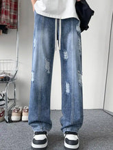 Men’s full size distressed wide leg jeans in light wash denim with ripped patches and a drawstring waistband