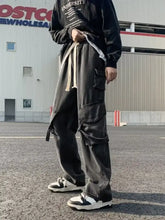 Men’s full size drawstring wide leg cargo jeans in black with multiple pockets and light-colored waistband detail