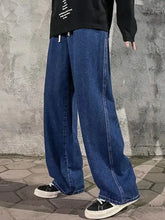 Men’s dark blue denim plus size wide leg jeans with drawstring and visible stitching along the seams