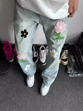Men’s full size wide leg jeans in light-wash denim embroidered with colorful pink black white and blue flowers