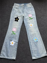 Men’s light-wash denim wide leg jeans with colorful pink black white and blue floral embroidery plus size