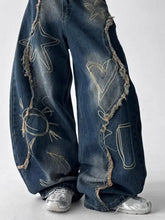 Men’s dark blue denim full size frayed hem wide leg jeans with embroidered star heart sun motifs and frayed edges