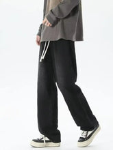 Men’s black corduroy wide-leg pants with white drawstrings featuring a loose fit and gradient wash design