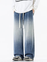 Men’s full size gradient wash wide leg denim pants with dark to light blue fade and white drawstrings in a relaxed fit