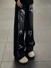 Men’s black wide-leg jeans with bold white graffiti print featuring heart motifs and abstract scribbles in plus size