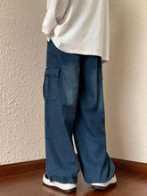 Men’s loose fit cargo jeans in medium blue denim with wide legs, cargo pockets, and elasticated cuffs for comfort