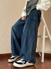 Men’s full size loose fit cargo jeans in medium blue denim with multiple pockets and elasticated cuffs