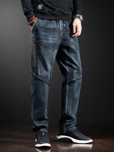Men’s loose fit dark blue denim jeans with faded wash and vertical gold lettering on the outer leg full size plus size