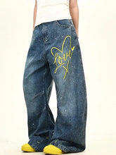 Men’s full size blue denim wide leg jeans with yellow love graphic and paint splatter details washed wide leg style