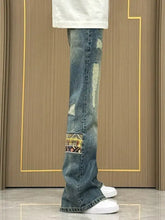 Men’s distressed blue denim wide-leg jeans with colorful embroidered patch for everyday wear plus size