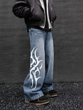 Men’s wide-leg jeans in blue denim fabric blend featuring a bold white flame graphic on the outer leg in plus size