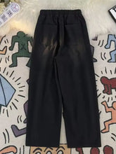 Men’s black wide-leg relaxed fit jeans with elastic waistband and two back pockets shown from the back side