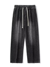 Dark gray denim pants with a relaxed fit, elastic waistband, and white drawstrings.