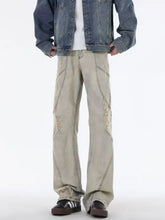 Men’s beige distressed denim size ripped wide leg jeans with raw edge rips and visible stitching plus size