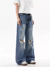 Men’s full size ripped wide leg jeans in faded blue denim with distressed and ripped details