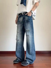 Men’s full size ripped wide-leg jeans in faded blue denim with intentional distressing at the knees