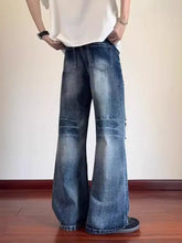 Men’s full size ripped wide-leg jeans in faded blue denim with distressed patches and raw hem detailing