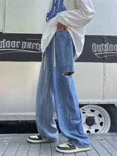 Men’s full size ripped wide leg jeans in light-wash blue denim with ripped knee and white drawstring waistband