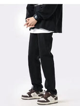 Men’s black tapered-fit slim fit jeans made of soft textured fabric with subtle seam stitching in full size slim fit
