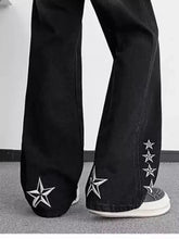 Men’s plus size black denim flare jeans with white star embroidery along the outer leg and cuff