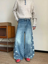 Men’s plus size wide leg denim jeans in faded blue with white star print along outer seams