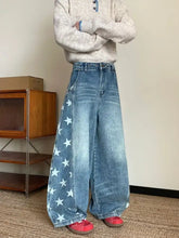 Men’s full size star print wide leg jeans in faded blue denim with white star patterns along the outer seam