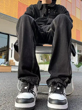 Black and white high-top sneakers with thick soles paired with men’s full size straight leg jeans in classic denim