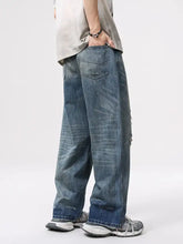 Men’s vintage distressed wide leg relaxed fit jeans in faded blue denim with distressed details and frayed hems