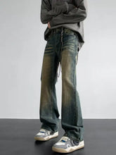 Men’s full size vintage wash loose fit jeans in distressed dark wash with faded green and brown accents and black cord detailing