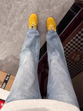 Mens full size vintage wash straight leg jeans paired with bright yellow sneakers featuring chunky sole and matching laces