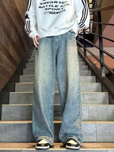 Men’s full size vintage wash wide leg jeans in faded blue denim with subtle distressing along the thighs