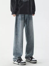 Men’s full size vintage wash wide leg jeans in faded blue denim with subtle distressing and raw hem detailing