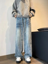 Men’s full size vintage wash wide leg jeans in light-wash denim with textured distressing patterns and plus size fit