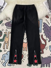 Men’s black denim full size vintage wash wide leg jeans with red star zipper details at the cuffs