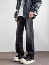 Black faux leather jacket with glossy finish and white text paired with men’s full size vintage wash jeans