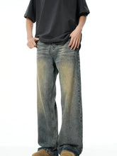 Men’s full size vintage wash wide-leg denim jeans with faded distressed look and subtle yellowish-green wash accents