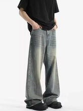 Men’s full size vintage wash wide leg jeans in denim with a faded gradient wash from dark gray to light blue