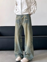 Men’s full size vintage wash wide leg jeans in faded distressed denim with a subtle yellowish-green wash
