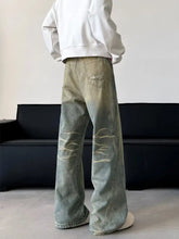 Men’s full size vintage wash wide leg jeans in faded green denim with distressed ripped detailing along the thighs