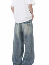 Men’s full size vintage wash wide leg jeans in denim with faded distressed look and subtle whiskering details