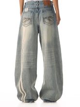 Men’s full size vintage wash wide leg jeans in faded blue denim with cream stripes and embroidered back pockets view