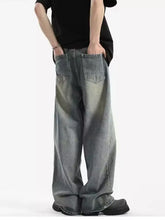 Men’s full size vintage wash wide leg jeans in faded gray denim with subtle distressing and classic back pockets shown from back