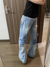 Men’s full size vintage wash wide leg jeans in light-wash denim with flared cut and distressed knee patches