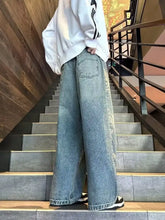 Men’s full size vintage wash wide leg jeans in light blue denim with subtle fading and frayed hems