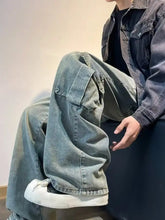 Men’s vintage wash wide leg jeans in faded blue denim with large cargo pockets and a relaxed oversized fit