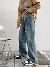 Men’s full size vintage wash wide leg jeans in faded blue denim with elastic waistband and white drawstrings