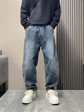 Men’s light-wash denim jogger pants with a relaxed tapered fit and subtle distressing in size wash loose fit style