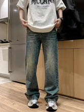 Men’s full size wash loose fit jeans in washed blue denim with relaxed straight-leg and faded distressing details