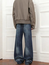Men’s full size wash loose fit jeans in medium-wash blue denim with wide leg and relaxed fade for casual wear