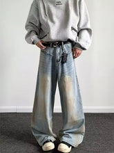 Men’s full size wash wide-leg jeans feature light-wash denim with faded distressing and a black belt accessory